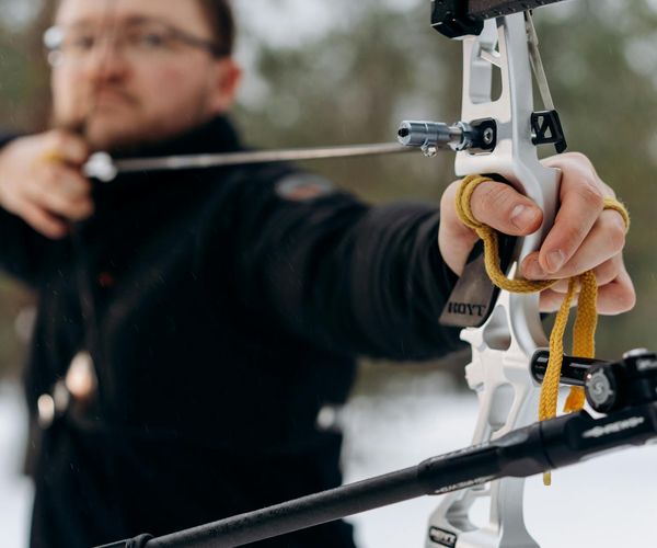 Man in a balanced stance outdoors with nature background.